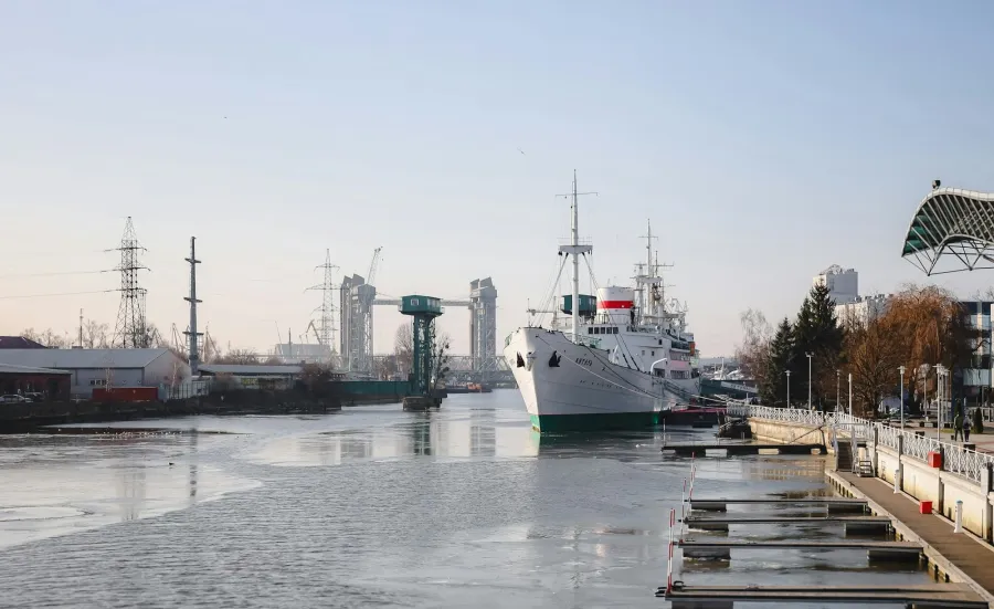 Large ship moored in industrial river scene