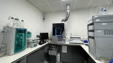 Analytical area at the environmental laboratory with advanced scientific instruments, computer monitor, and exhaust pipe