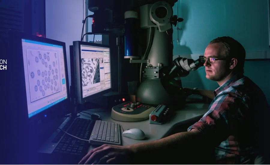 A man in a lab examines images on computer monitors in a dimly lit research environment. The Southampton Medical Research Services logo is overlaid.