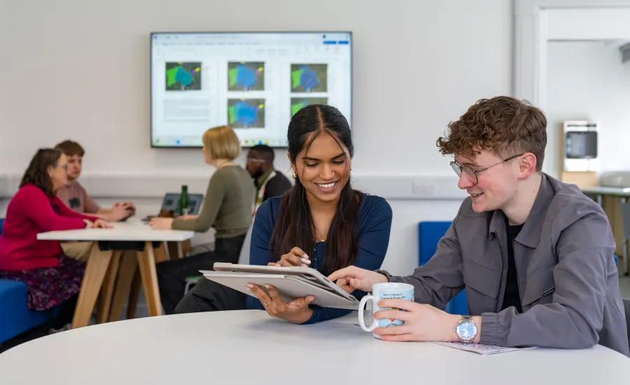 Two students using a tablet in a University study space.