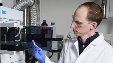 Dr Gordon Inglis analysing molecular fossils using a liquid chromatograph mass spectrometer in a laboratory setting.