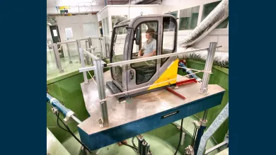 Research participant seated within a six-degree-of-freedom motion simulator in a laboratory