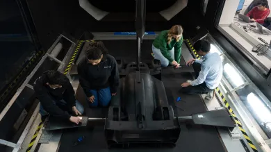 Researchers working on a model racing car in the University of Southampton's wind tunnel facility