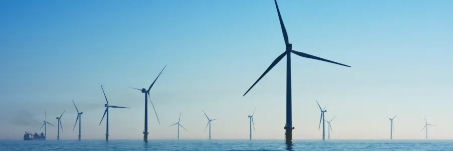 Wind turbines surrounded by water.
