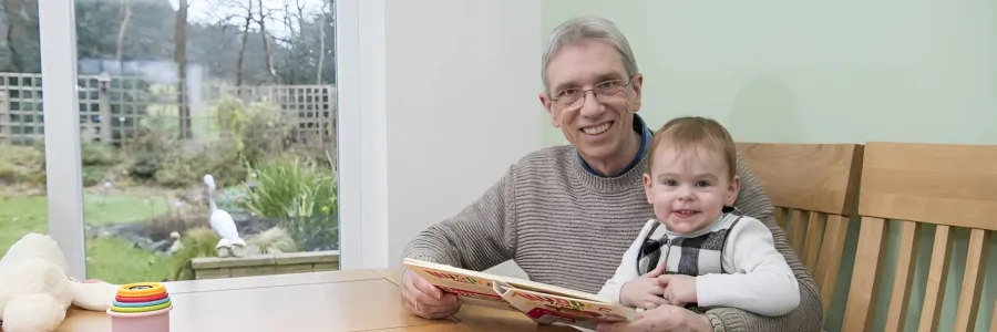 Mike and his grandson sitting in the light and airy dining room at the dining table.
