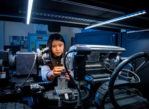 A mechanical engineering student uses a piece of complex machinery