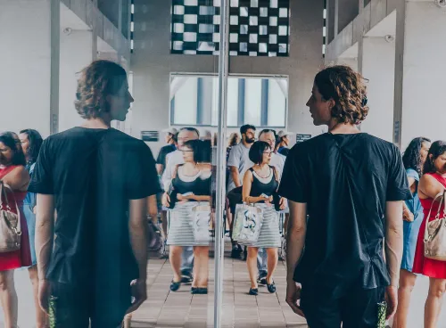 Man looking at his reflection in a window
