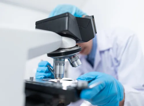Image of a medical researcher using a medical microscope.