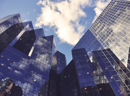 Low-angle view of city office buildings reflecting the sky