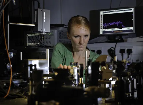 Professor Anna Peacock at work surrounded by equipment in the photonics lab