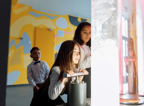 Children looking at coloured liquids in large tubes
