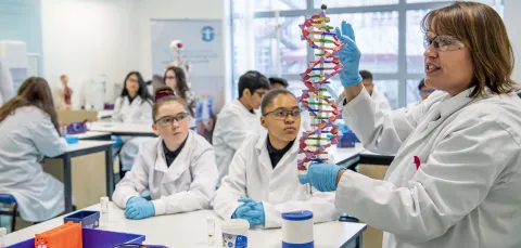 School children in lab coats learning in the Life Lab.