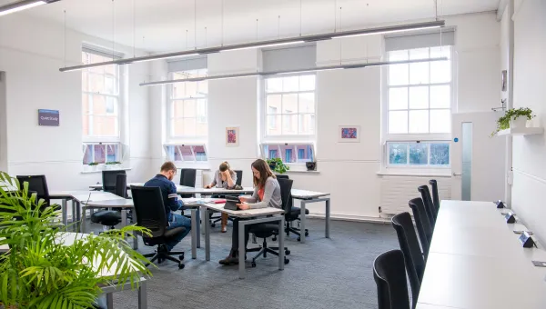 Students studying at desks in a bright, airy room.