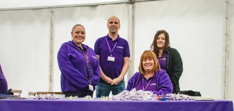 Members of the 24/7 halls support team in uniform behind a table. 