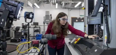 Student adjusting machinery in the Testing Structures Research Laboratory. 