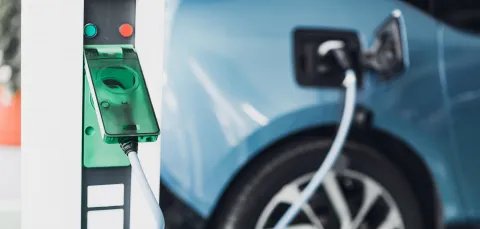 Electric car charging point with car plugged in. 