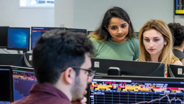 Business analytics degree students looking at Bloomberg screens