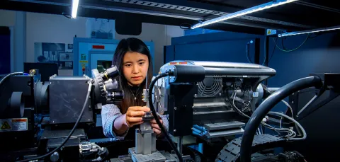 A mechanical engineering student uses a piece of complex machinery