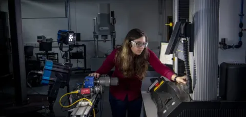 A student uses a piece of equipment in the testing and structures research lab