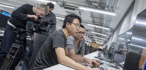 Two students working at a computer in the David Barron computing lab.