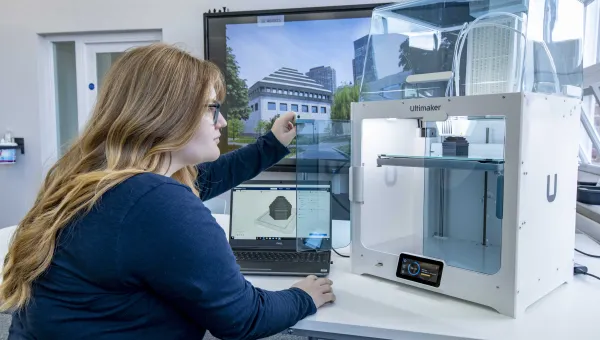 A student inspecting the finished construction of her latest 3D printed object.