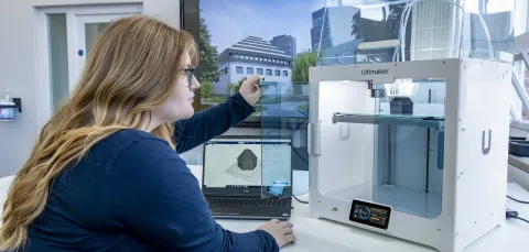 A student inspecting the finished construction of her latest 3D printed object.