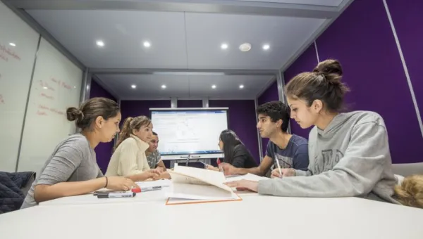 Group of students at work around a table in the maths student centre.