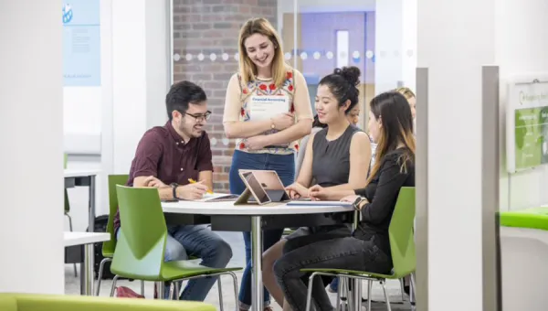 Four business students sitting around a table discussing their work