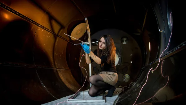 A student checks their experiment in the electric propulsion lab