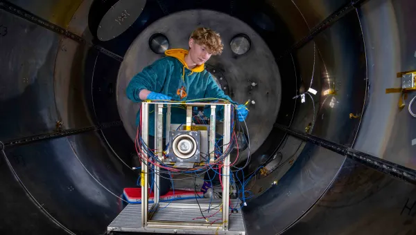 A student works on an experiment in the electric propulsion lab