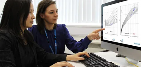 Clinical data researchers compare graphs on a computer screen