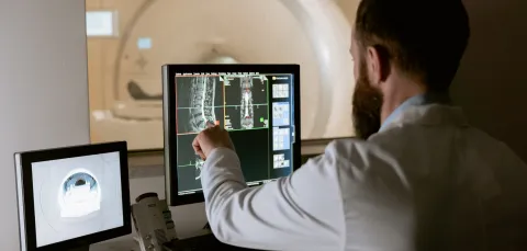 Healthcare professional monitoring an MRI scan and viewing the results