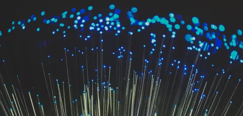 Lit-up optical fibres bristling against a black background