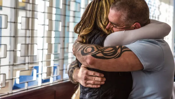 A man and woman hug tightly