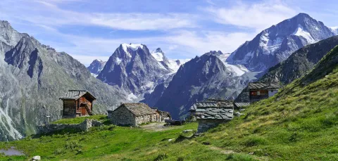 Looking across green fields towards the peaks of the Arolla mountains