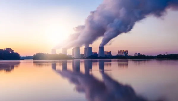 A landscape image of a coal-fired power station expelling pollution into the sky.