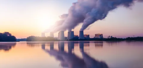 A landscape image of a coal-fired power station expelling pollution into the sky.