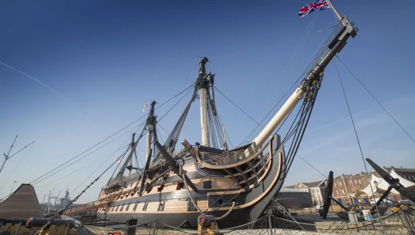 An exterior view of HMS Victory docked at Portsmouth Historic Dockyard.