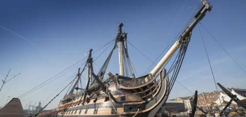 An exterior view of HMS Victory docked at Portsmouth Historic Dockyard.