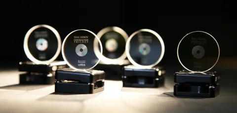 A row of 5 memory crystals on stands, softly lit against a black background. They have been imprinted with copies of the Foundation trilogy by Isaac Asimov.
