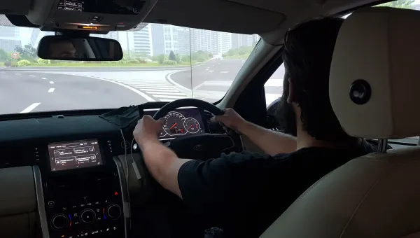 Student with both hands on the wheel of a driving simulator