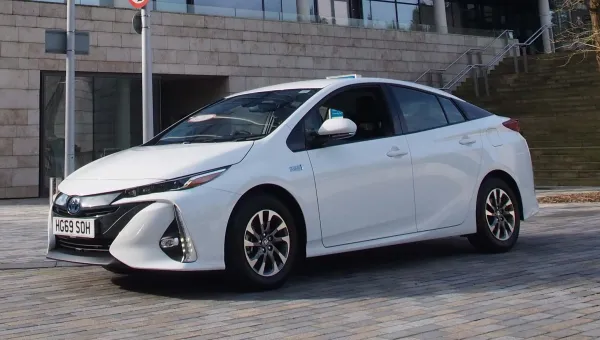 A white car parked outside of a university building