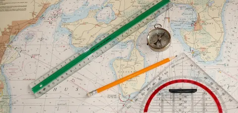 Nautical chart with a pencil, ruler and compass on it