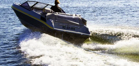 A powerboat cuts through the water away from the camera