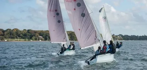 Three sailing boats sailing near the shore