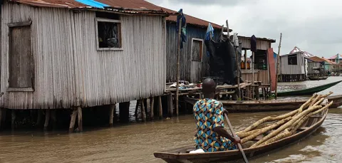 A resident of Ganvie stilt village in Benin navigates a boat through water