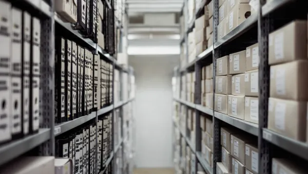 looking along 2 columns of shelves of archive files and boxes