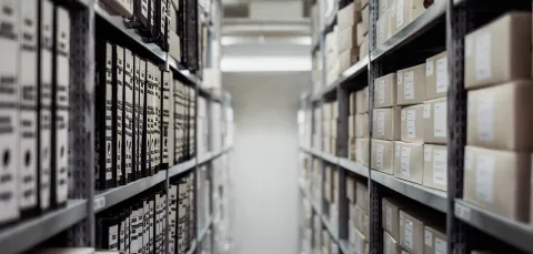 looking along 2 columns of shelves of archive files and boxes