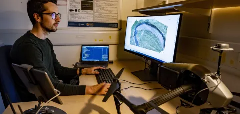 One researcher analysing geospatial data with a computer