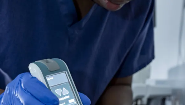 A PhD researcher measuring the tissue tone of a volunteer in the Pressure Lab